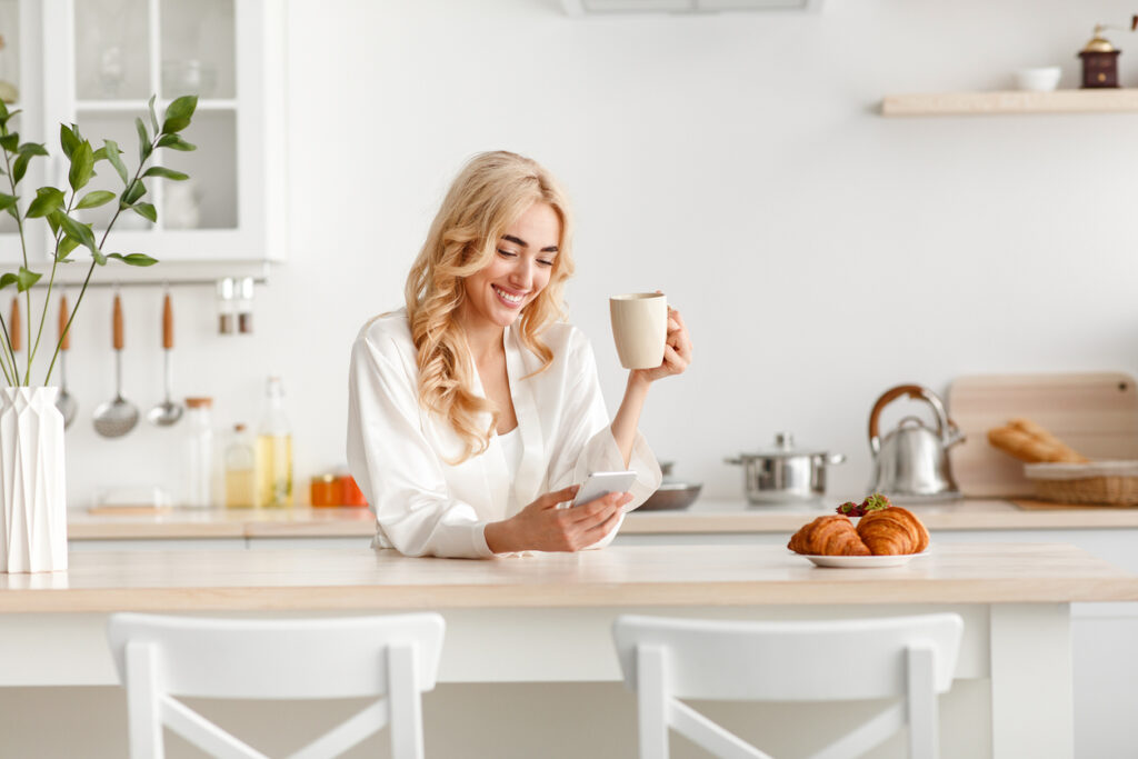 Ragazza al cellulare mentre fa colazione