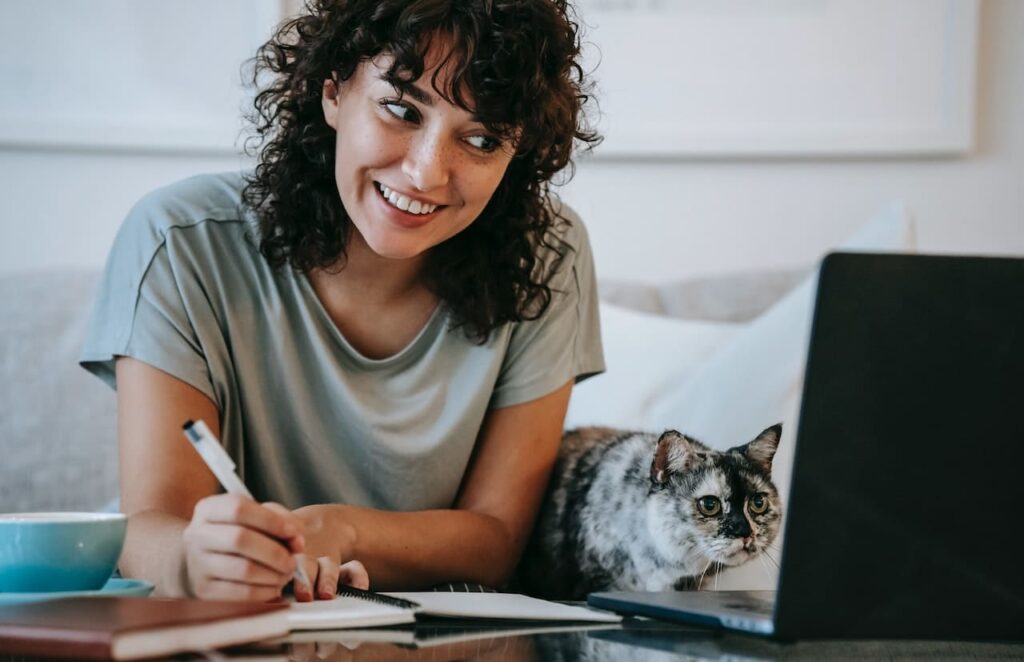 ragazza che studia al pc con gatto vicino