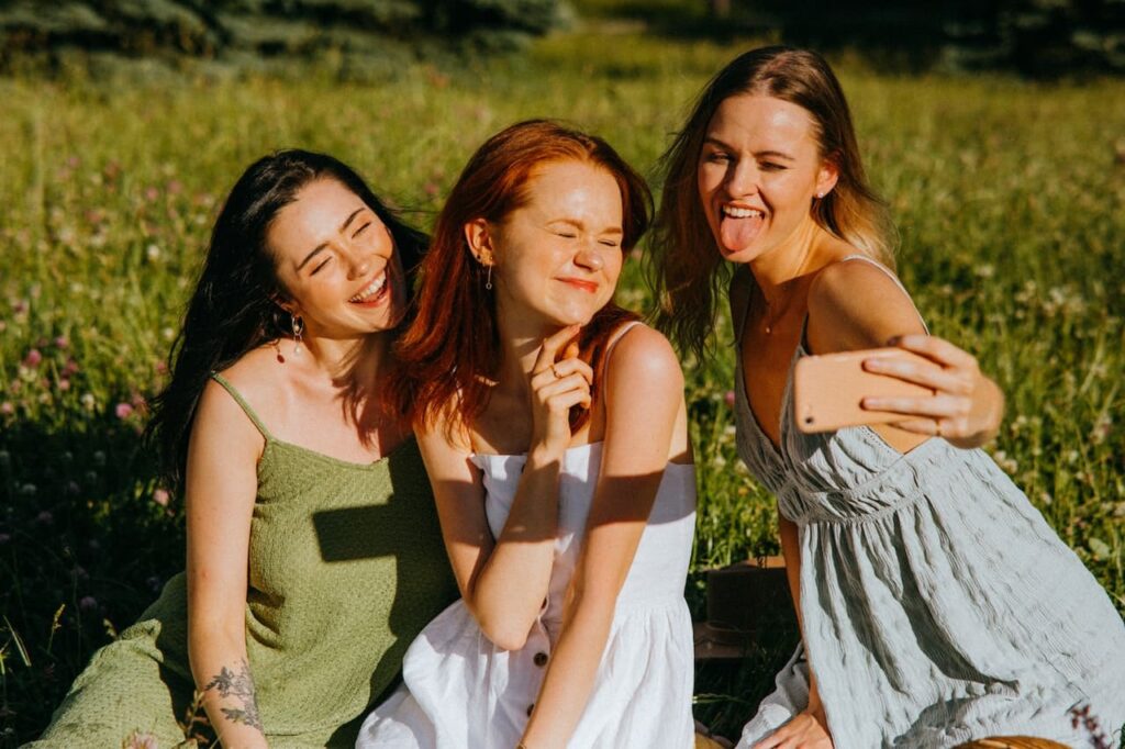 amiche sul prato e al sole che si scattano una foto