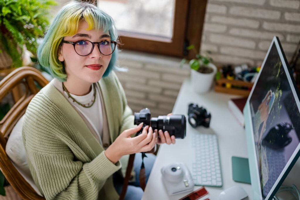 ragazza con i capelli colorati al pc mentre scarica delle foto