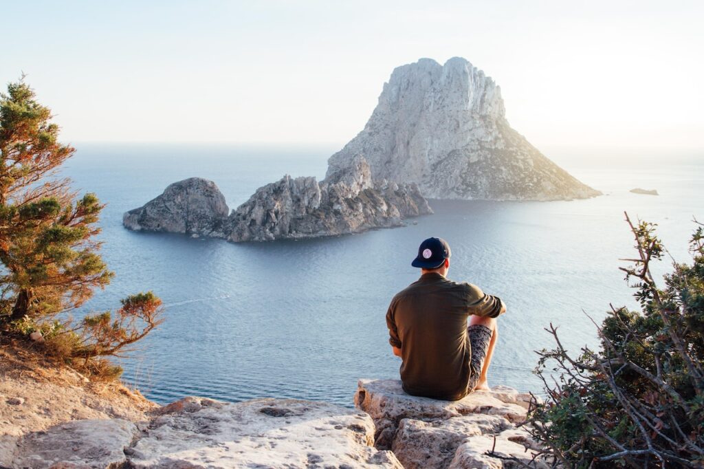 ragazzo con cappello che guarda il panorama e il mare