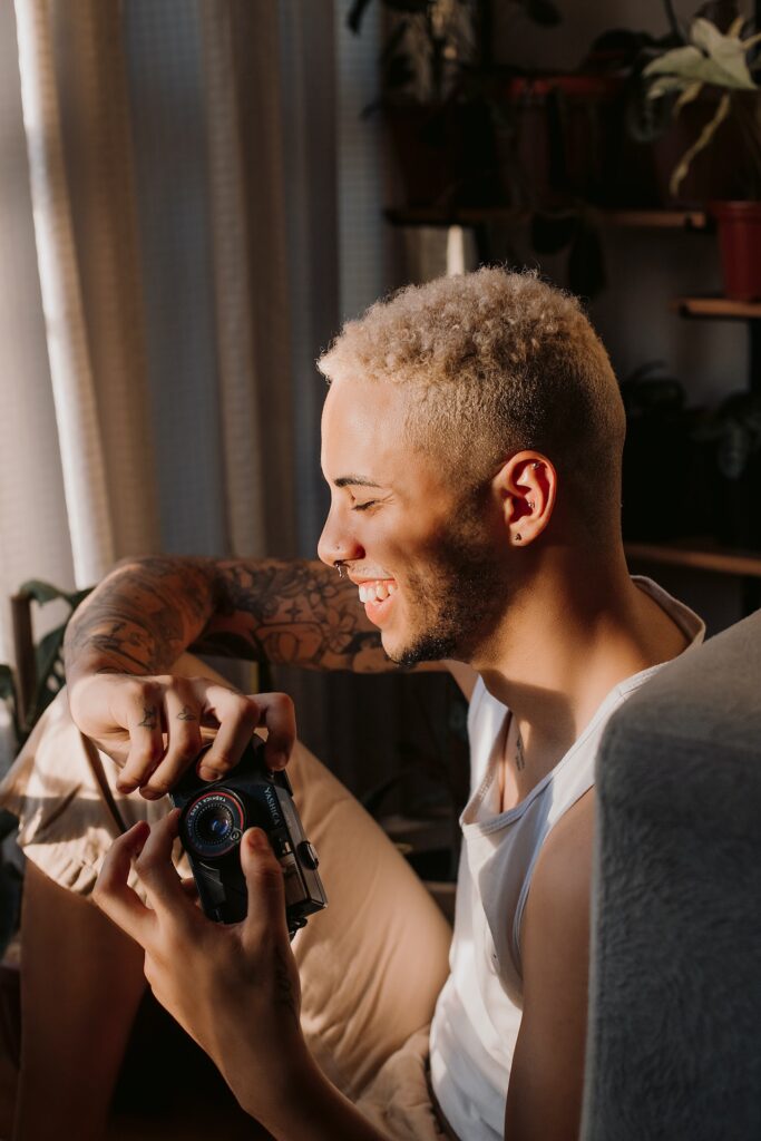 ragazzo che sorride con la macchina fotografica