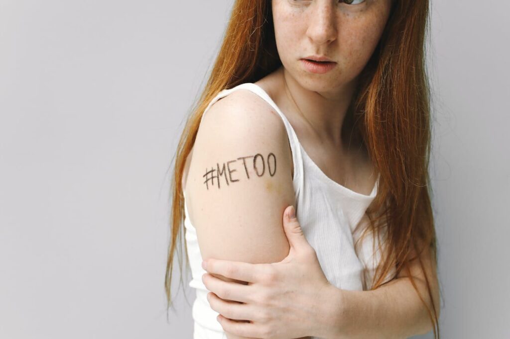 ragazza dai capelli rossi e lunghi con un hastag disegnato sul braccio