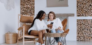 Instagram vs TikTok: il confronto delle performance di Inflead due ragazze sedute che guardano un contenuto sui social